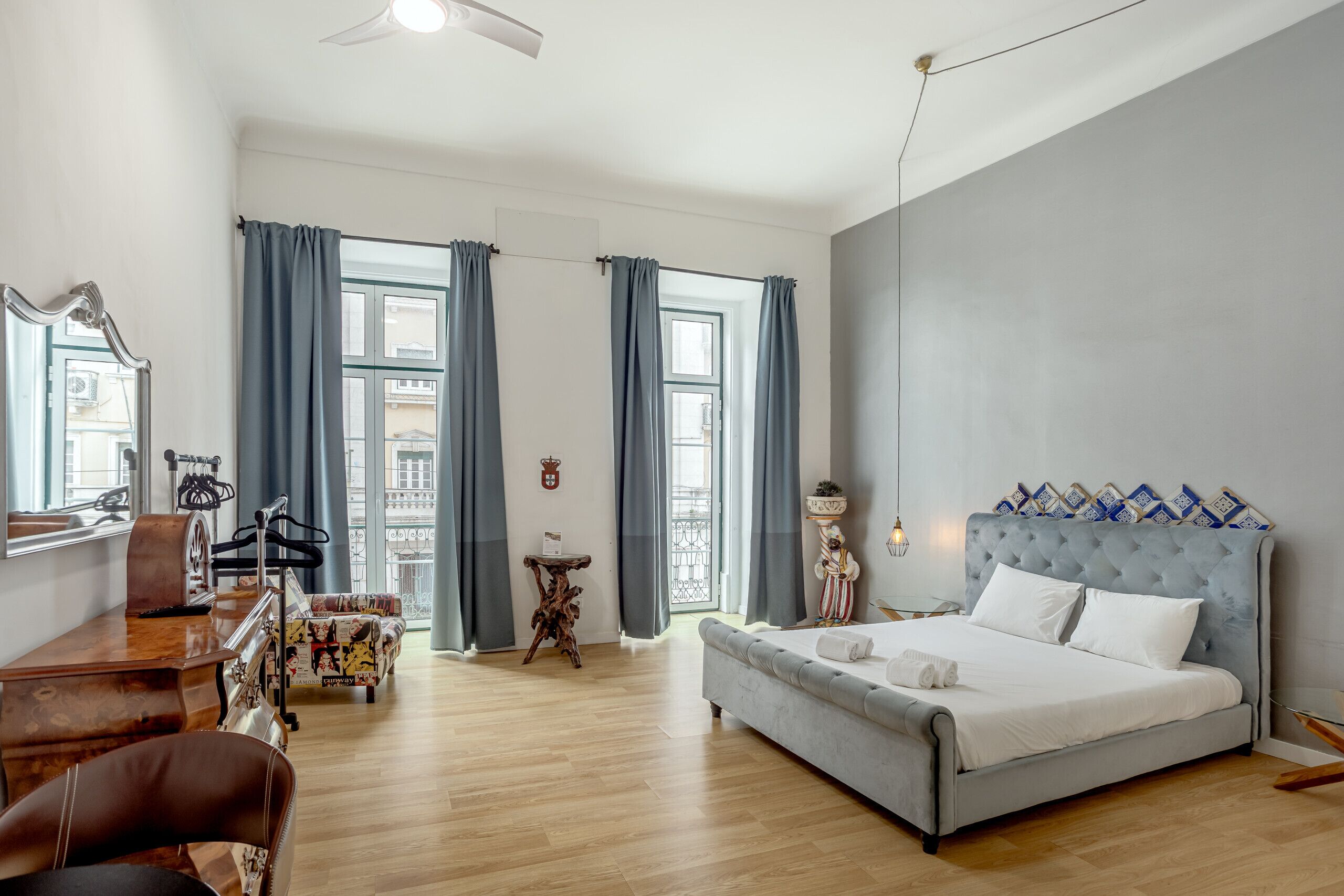 Une chambre d’hôtel moderne équipée d’un lit, d’un bureau, d’une chaise, d’une petite table et d’une grande fenêtre.