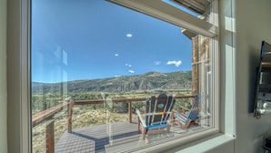A balcony with a view of a mountainous landscape, two Adirondack chairs, and a wooden deck. - Spacious mountain chalet with breathtaking views on all sides, just 15 minutes from Monarch Ski Area and 15 minutes from downtown Salida. (Salida)