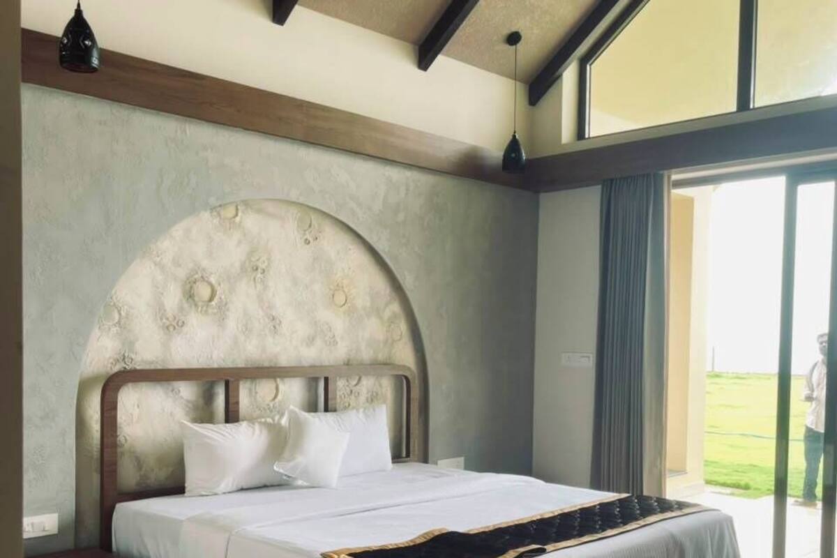 Un dormitorio con una cama grande, ventilador de techo, ventana y vistas al exterior.