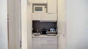 Una cocina compacta equipada con microondas, tostadora y hervidor.