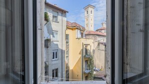 A narrow street with buildings, a bell tower, and a window with a view of the street. - Conte Verde - Bilo 7 Grey by Wonderful Italy (Turin)