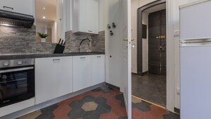 A kitchen with white cabinets, a built-in oven, a sink, and a backsplash. - Conte Verde - Bilo 7 Grey by Wonderful Italy (Turin)