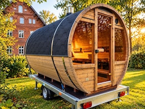 Una estructura cilíndrica de madera con puerta y ventanas, montada sobre un remolque.