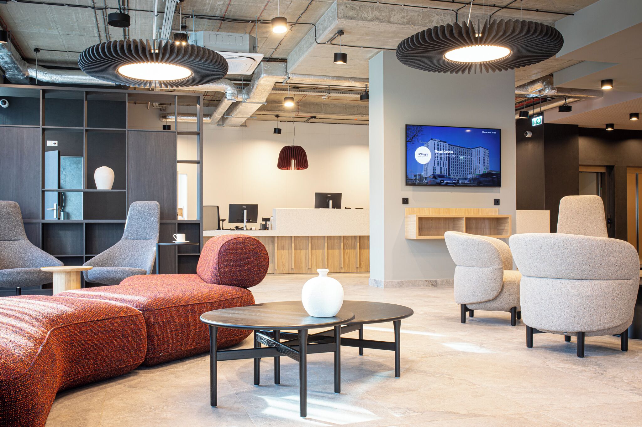 A modern interior with seating, a coffee table, and a TV mounted on the wall.
