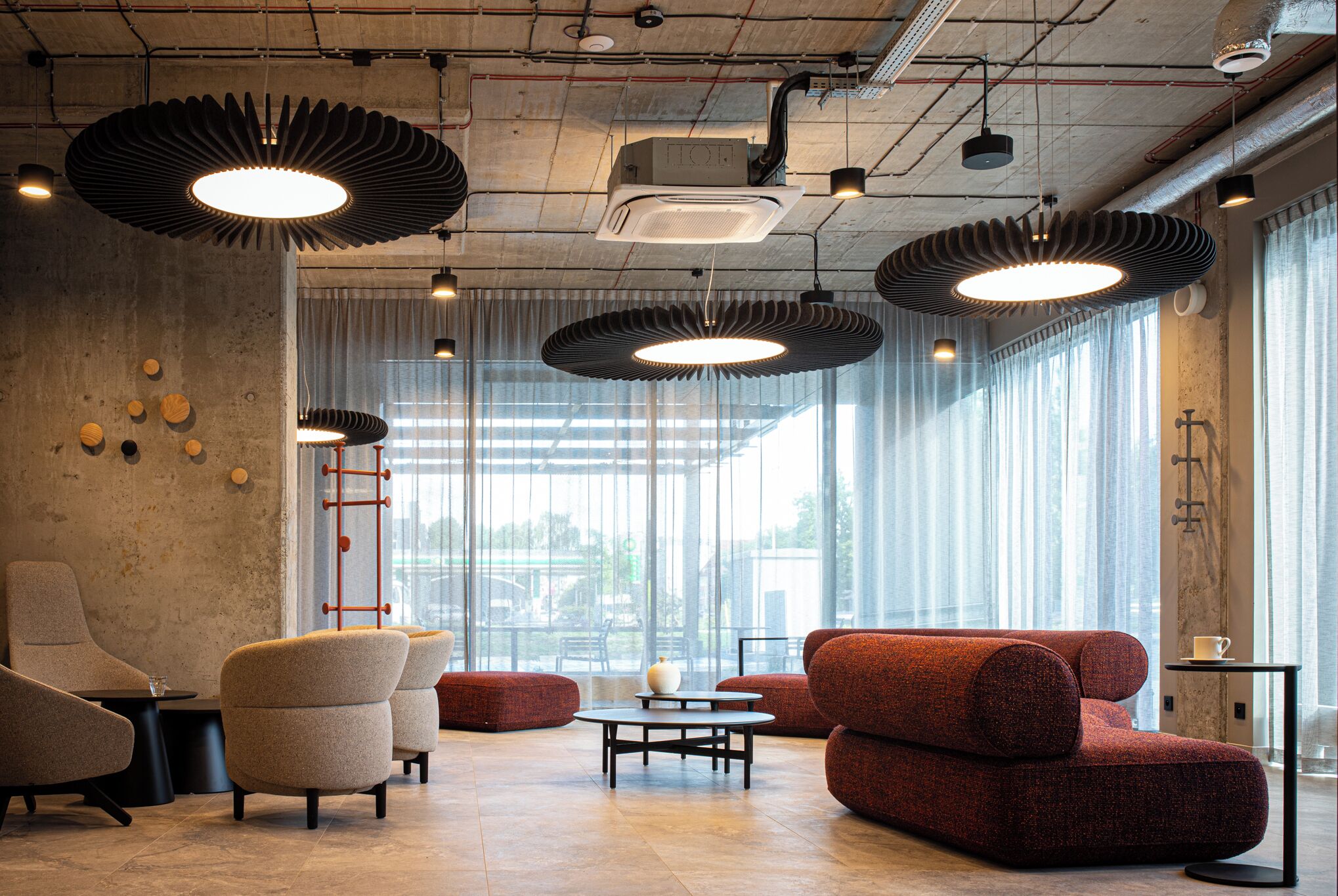 Un interior moderno con techo alto, iluminación de estilo industrial y ventanas amplias.