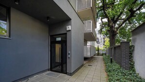 Een smalle steeg met een gebouw, een inkom, een deur en een klein raam.