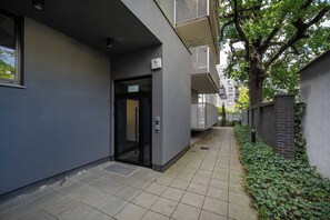 Une ruelle étroite avec une entrée d’immeuble, une porte et une petite fenêtre.