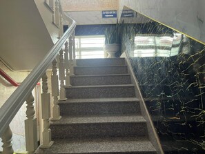 Una escalera con paredes de mármol y barandilla.