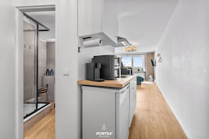 Eine moderne Küche mit Kaffeemaschine, Backofen und Blick ins Freie.