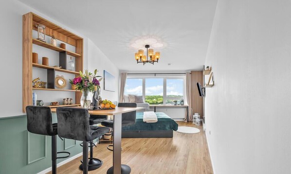 Ein modernes Zimmer mit Essbereich, einem Bett, einem Fenster mit Blick und einem Kronleuchter.