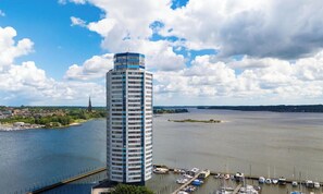 Ein Hochhaus mit einem Yachthafen und Booten im Vordergrund.