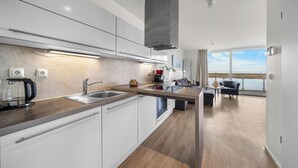 A modern kitchen with white cabinets, stainless steel appliances, and a view to the outside. - Modern apartment with exceptional sea view and balcony at Marina Wendtorf (Wendtorf)