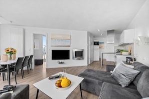 A modern apartment with a dining area, living room, kitchen, and a fireplace. - Modern apartment with exceptional sea view and balcony at Marina Wendtorf (Wendtorf)