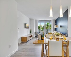 Ein moderner Essbereich mit Holztisch, weißen Stühlen und Pendelleuchten.