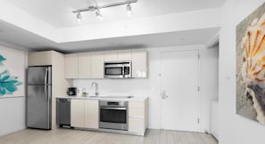A modern kitchen with stainless steel appliances, a dishwasher, and a microwave. - Luxury 1BR - Bay View - Beachwalk Beach Resort (Hallandale Beach)