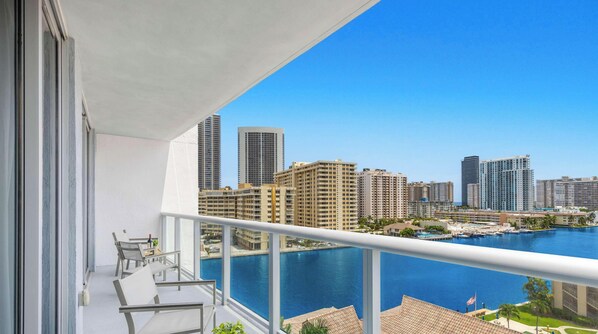 A balcony with a view of a marina and high-rise buildings. - Luxury 1BR - Bay View - Beachwalk Beach Resort (Hallandale Beach)