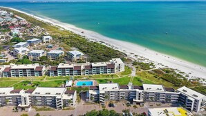 Un hotel sulla costa con diversi edifici, una spiaggia e una vista libera sull'oceano.