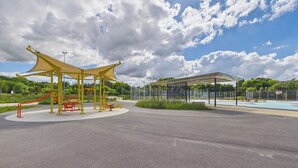 Een buitenspeeltuin met klimconstructies en een overdekt zitgedeelte.