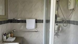 A bathroom with a sink, towel rack, shower, and toiletries. - Room-amina's Cottage Women Only Accommod (Gloucester)