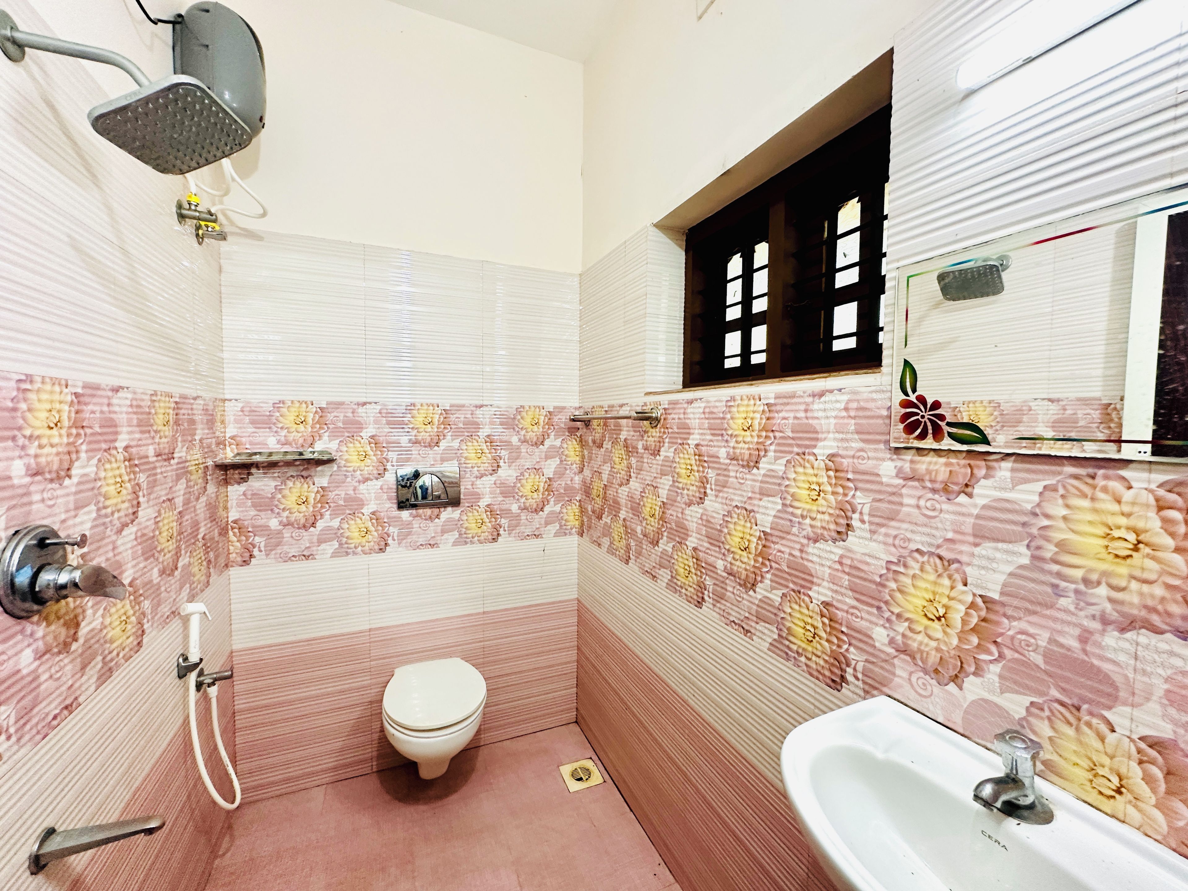 Un baño con inodoro, lavamanos, ducha y espejo.