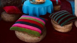 Una persona de pie junto a una mesa, con vista al paisaje desértico.