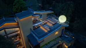 Une maison moderne dotée d’un grand balcon, d’une structure évoquant la lune et d’un espace piscine.