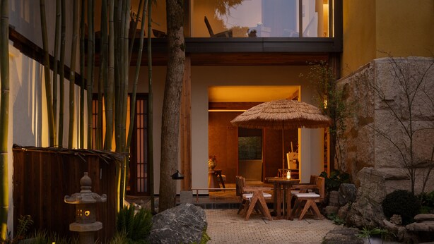A traditional Japanese-style garden with a stone lantern, bamboo, and a thatched umbrella. - Liaoxin Valley Forest Hotel (Chengdu)