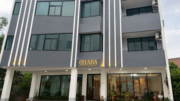Un hotel de varios pisos con un diseño moderno, que cuenta con grandes ventanales y una entrada destacada.