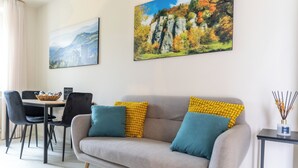 A living room with a sofa, chairs, a dining table, and artwork on the walls. - Modern and refined country house (Bibbiena)