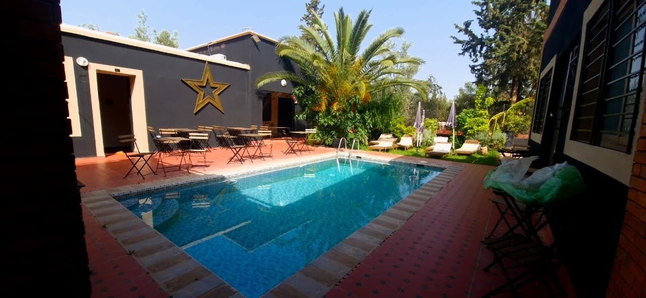 Una piscina con sillas de descanso y una decoración con estrellas en un edificio.