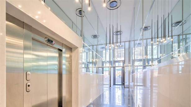 A modern elevator with a digital display, a polished floor, and a glass facade with natural light. - 1-bedroom Lodge Stay in Antwerp (Antwerp)
