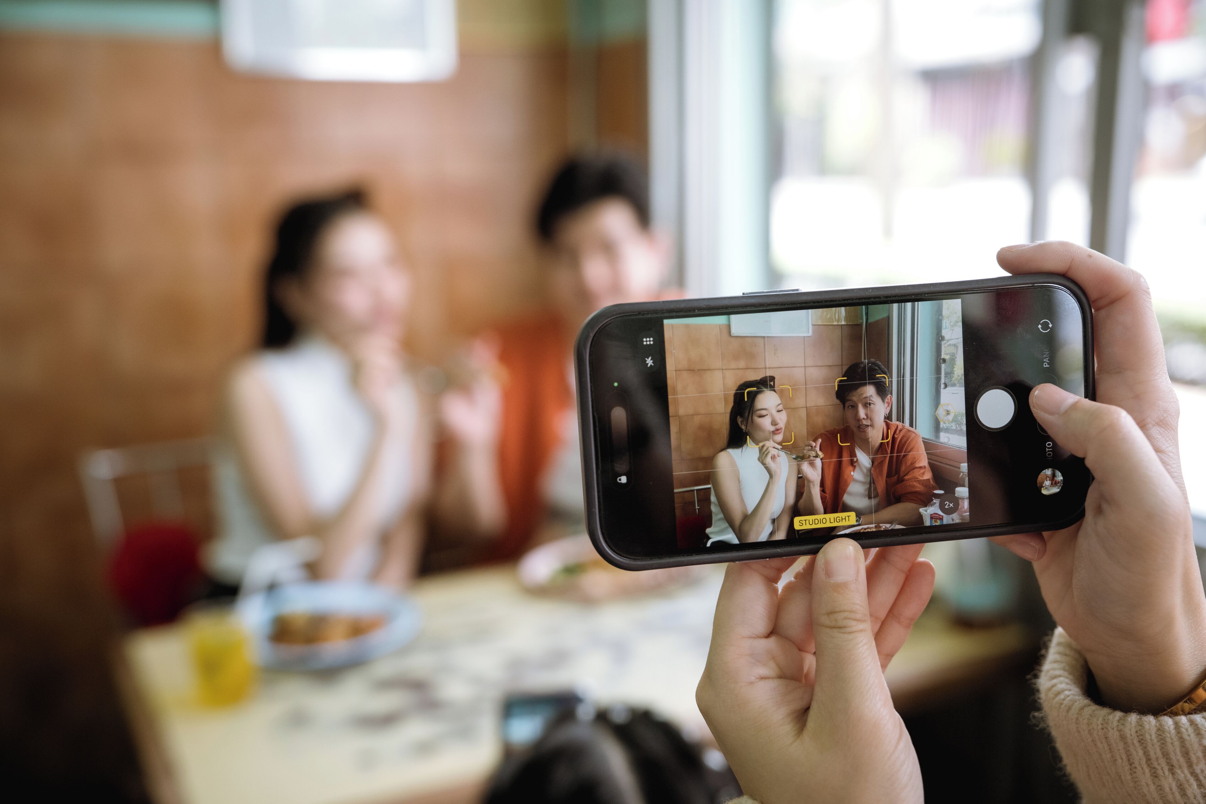 A smartphone displaying a video call with two people in a room.