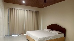 A bedroom with a bed, curtains, and a wooden ceiling. - Aarambh The Creek Breeze Resort (Palghar)