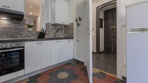 A modern kitchen with white cabinets, a black oven, and a hexagonal tile floor. - Conte Verde - Bilo 7 Grey by Wonderful Italy (Turin)