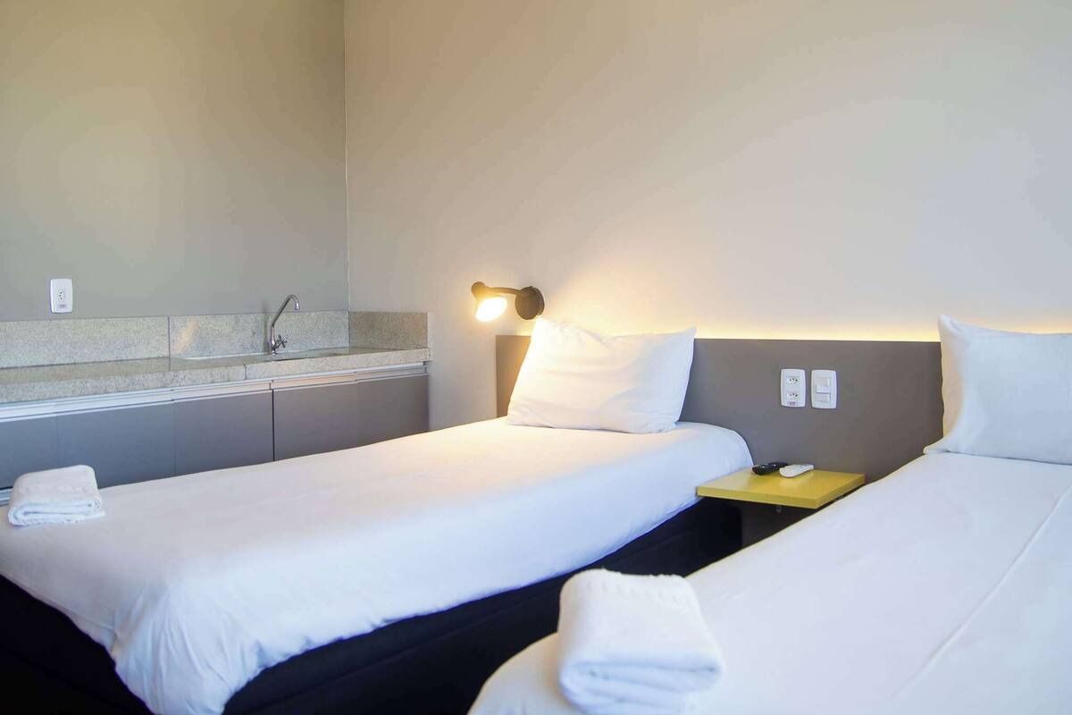 Habitación estándar con 2 camas individuales | Espacio para trabajar con un portátil y cortinas opacas