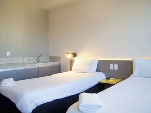 Habitación estándar con 2 camas individuales | Espacio para trabajar con un portátil y cortinas opacas