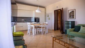Um espaço compacto com cozinha compacta, área de refeições e sofá verde.