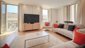 A modern living room with a flat-screen TV, a sofa, a coffee table, and a balcony with a view. - Stunning Apartment a/c 6P With Sea View - Cannes (Cannes)