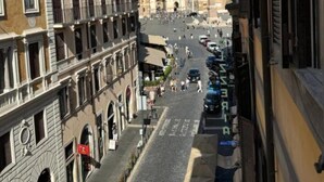 Una vista di una strada con edifici, un cielo sereno e un obelisco in lontananza.