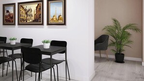 Ein modernes Interieur mit einem Essbereich, drei gerahmten Stadtansichten und einer Topfpflanze.