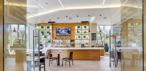 Eine moderne Bar mit Fernseher, Holztresen und Sitzgelegenheiten.