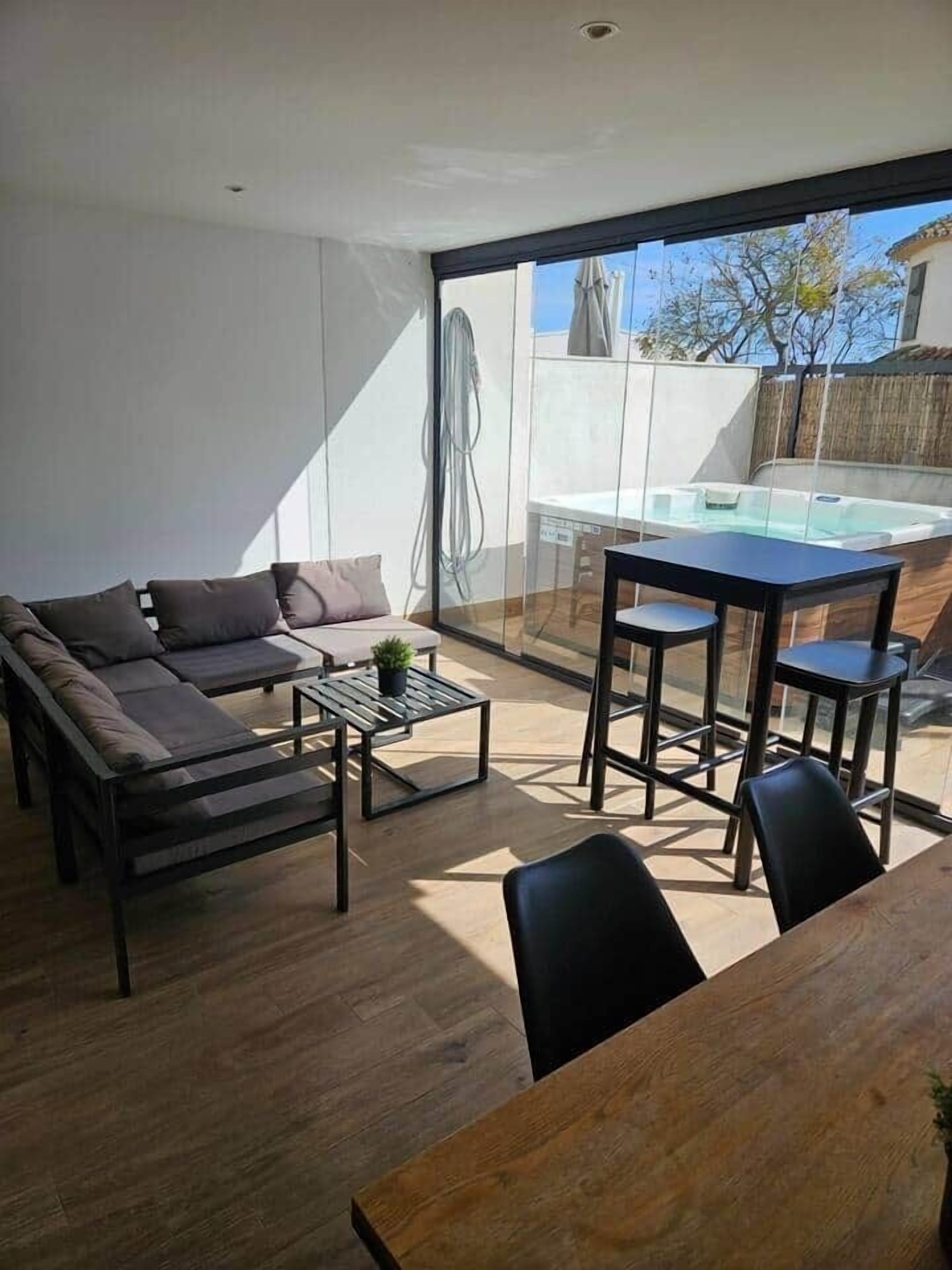 Una sala de estar moderna con sofá, mesa de centro y mesa de comedor.