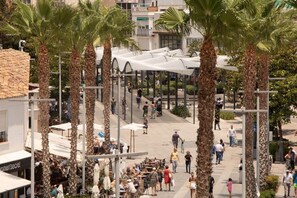A public square with palm trees, outdoor seating, and a covered area. - Amazonia – Downtown Torremolinos – Quiet Apartment for 4 Gue (Torremolinos)