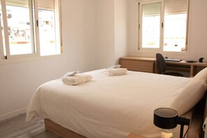 A hotel room with a bed, a desk, a chair, and a lamp. - Amazonia – Downtown Torremolinos – Quiet Apartment for 4 Gue (Torremolinos)