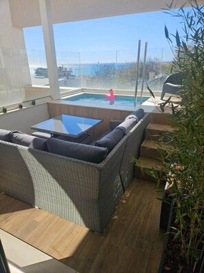 A balcony with a wicker sofa, a glass table, and a view of the sea. - Horizon Del Mar – Sea Views & Plunge Pool – 2BR, 2BA, Sleeps (Torremolinos)