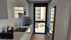 Una cucina moderna con pensili bianchi, un piano di lavoro nero e un forno integrato.