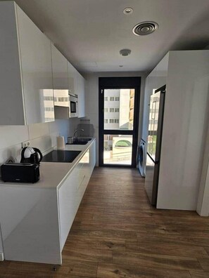 A modern kitchen with white cabinets, a black countertop, and a built-in oven. - Horizon Del Mar – Sea Views & Plunge Pool – 2BR, 2BA, Sleeps (Torremolinos)