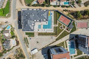 An aerial view of a property with a swimming pool, tennis court, and a parking area. - Annabella Residence (Alanya)