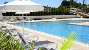 Une piscine avec des chaises longues et des parasols.