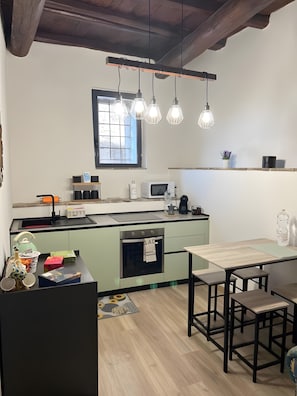 Una cocina moderna con techo de madera, una ventana y un comedor con mesa y bancos.